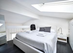 - une chambre blanche avec un grand lit blanc et 2 oreillers dans l'établissement STUDIO THE BEACH - Regarda Travel, à Bardolino
