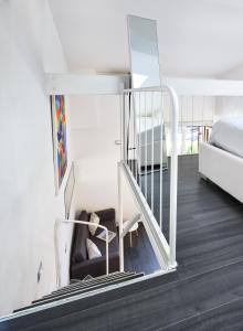 - un escalier dans une chambre avec un lit et un canapé dans l'établissement STUDIO THE BEACH - Regarda Travel, à Bardolino