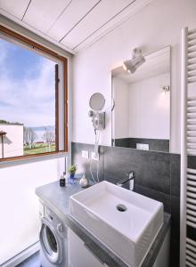 y baño con lavabo y espejo. en STUDIO THE BEACH - Regarda Travel, en Bardolino