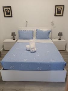 1 cama con edredón azul y almohadas azules en Pico dos Anjos, en Porto Moniz