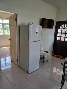 a white refrigerator in a kitchen with a table at Posh Homes Getaway in Christ Church