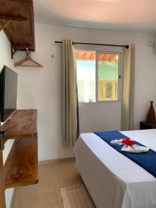 um quarto com uma cama e uma janela em Kailua apartamentos e suítes em Porto de Galinhas