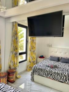 1 dormitorio con 1 cama y TV en la pared en Casa Amaya 208, en Costa de Antigua