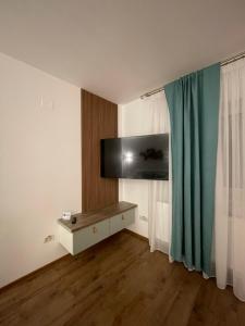 a room with a television and a table with a curtain at Arena Studio in Piteşti