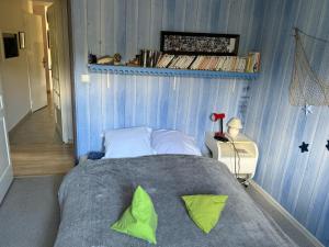 um quarto com uma cama grande e almofadas verdes em Maison d'hôte Soisy em Soisy-sur-Seine