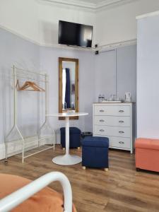 a bedroom with a bed and a table and a dresser at The Windmill Hotel in London