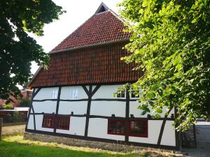 Brunottescher Hof في Wallenstedt: مبنى ابيض واسود بسقف احمر