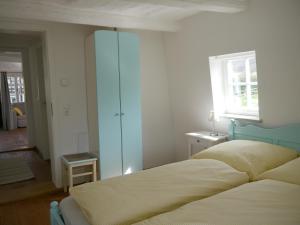 - une chambre avec un lit, une fenêtre et un miroir dans l'établissement Brunottescher Hof, à Wallenstedt