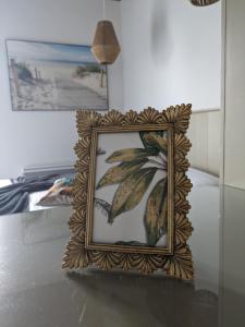 a framed picture of a plant on a table at L'Ile sous le Vent in Sainte-Marie-de-Ré