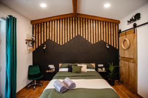 a bedroom with a large bed with a black headboard at Skyway Borsec Connection Hideaway in Borsec