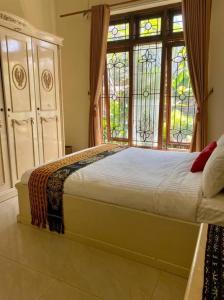 a bedroom with a bed with a large window at homestay kenari pusat kota in Demangan