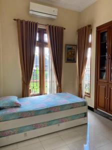 una camera con un letto di fronte a una finestra di homestay kenari pusat kota a Demangan