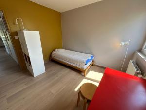 mały pokój z łóżkiem i stołem w obiekcie Devant les grands chalutiers w La Rochelle