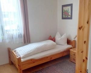 a bedroom with a wooden bed with a window at Ferienwohnung Steuerberg in Feldkirchen in Kärnten