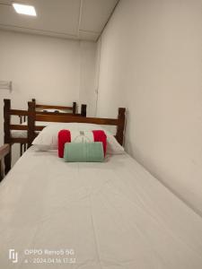 - un lit avec des oreillers rouges et verts dans l'établissement HOSTEL BARRA FUNDA LTDA, à São Paulo