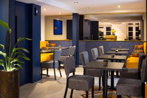 a restaurant with tables and chairs and a bar at Hôtel Le Nautilus in Saint Malo