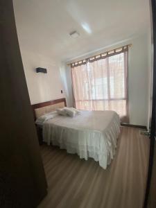 1 dormitorio con cama y ventana grande en Pent House Exclusivo, en Loja