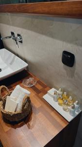 a bathroom counter with a sink and a basket of candles at Pearl House in Hydra