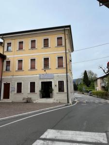 a yellow building on the side of a street at Locanda Moscal in Affi