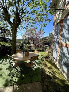 a table and chairs in a yard with a tree at Maison de charme avec jardin - Proche Lyon - in Vienne