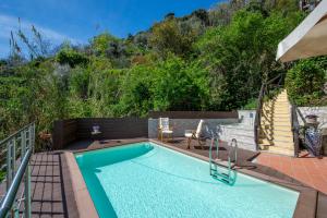 a swimming pool with a hill in the background at Solaria in Amalfi