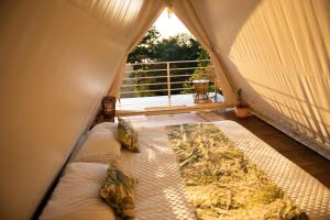 a room with a bed in a tent with a window at Quimera Glamping in Pacuar