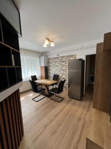 uma cozinha com mesa e cadeiras num quarto em Bingo Apartman em Cristuru Secuiesc
