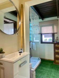 un baño con lavabo y espejo en Bungalow Aloha, Piscina Privada, Playa y Barbacoa, en Benalmádena