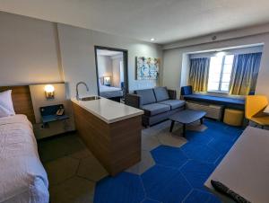 a hotel room with a bed and a couch at Microtel Inn & Suites by Wyndham Rapid City in Rapid City