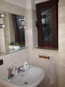bagno con lavandino e specchio di Casa Vacanze Mare Trinitapoli a Trinitapoli