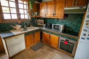 eine Küche mit Holzschränken und einem weißen Kühlschrank in der Unterkunft Chambres d Hôte Bords de Seine Vernon-Giverny in Vernon