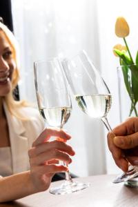 a woman holding two glasses of white wine at Residenze Chamur- Grattacielo in Palermo