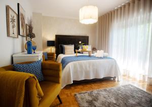 um quarto com uma cama e um sofá em Maria Home Reall's em Braga