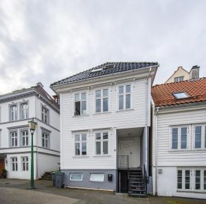 a white house with a garage and two buildings at Nordnes Studio Apartment in Bergen