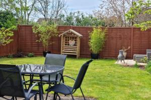 a yard with a table and chairs and a fence at Ivy House in Northampton