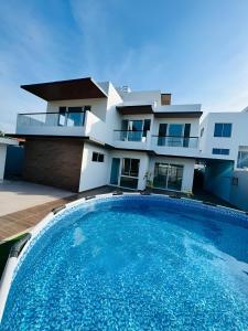 una piscina frente a una casa en AzulRest Casa de Verano en Juan de Acosta