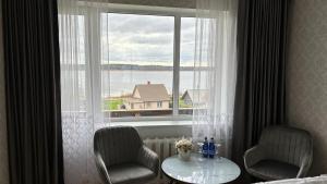 2 sillas y una mesa frente a una ventana en Promenaadi Apartment en Võru