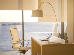 a desk with a chair and a laptop on it at Hotel Kompas in Dubrovnik