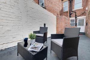 a patio with two chairs and a table with a newspaper at Newcastle CITY Apartments 5 in Newcastle upon Tyne