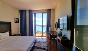 a hotel room with a bed and a view of the ocean at Villa Nha Trang Gần Biển - Biệt Thự Nha Trang Gần Biển in Nha Trang