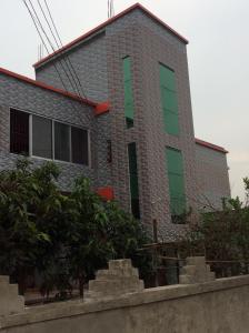 a brick building with green and red windows at ApartmenT - Homestays in Sylhet