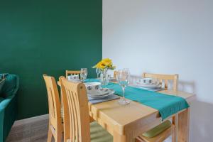 a dining room with a table with a green wall at Modern Freshly Refurbed Home Luton in Luton