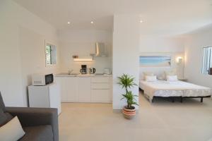 a white room with a bed and a kitchen at Apartamentos Casa Franziska in Talamanca