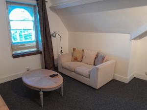 ein Wohnzimmer mit einem Sofa und einem Tisch in der Unterkunft Large Loft room share bathroom R9 in Swansea