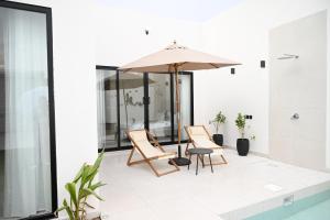 a patio with a table and chairs and an umbrella at شاليه زهر Zahr Chalet in Banī Ma‘n
