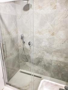W łazience znajduje się prysznic ze szklanymi drzwiami. w obiekcie Central Luxe Apartment w Tiranie