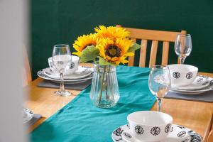 una mesa con un jarrón de girasoles sobre una mesa en Modern Freshly Refurbed Home Luton en Luton