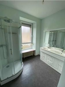 uma casa de banho com uma cabina de duche em vidro e um lavatório. em Jolie maison familiale em Guingamp