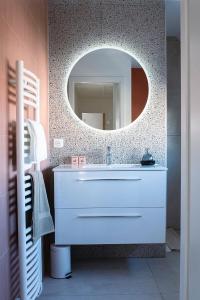 uma casa de banho com um lavatório branco e um espelho. em Villa Claber em Huningue