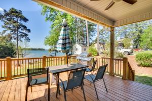 eine Terrasse mit einem Tisch, Stühlen und einem Sonnenschirm in der Unterkunft Starr Rental on Lake Hartwell Deck and Water View! 